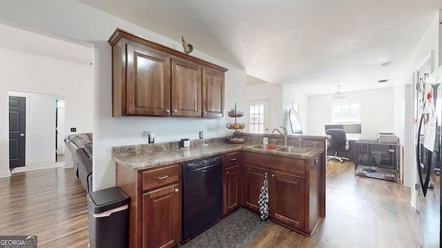 kitchen featuring open floor plan, black dishwasher, a peninsula, dark wood-style floors, and a sink