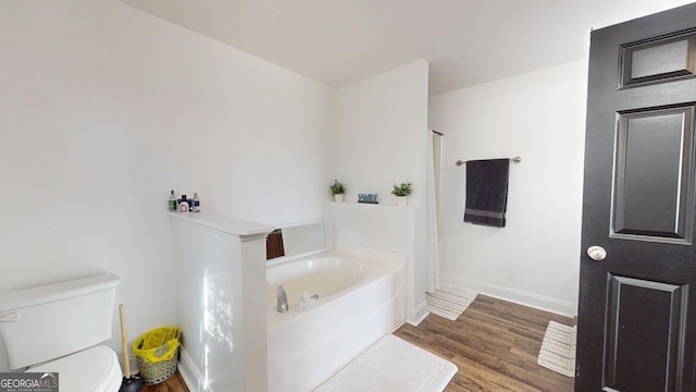 bathroom with baseboards, toilet, wood finished floors, a bath, and a shower