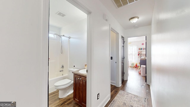 full bathroom with visible vents, a healthy amount of sunlight, wood finished floors, and vanity