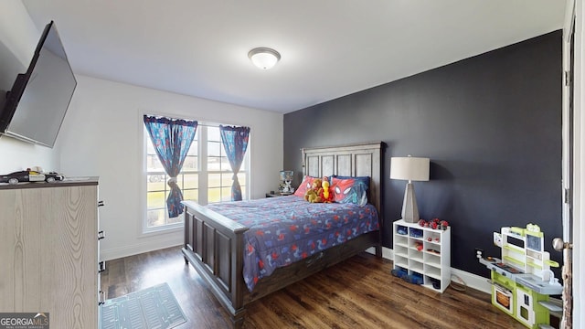 bedroom featuring baseboards and dark wood-style flooring