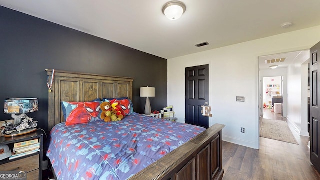 bedroom featuring visible vents, baseboards, and dark wood-style floors