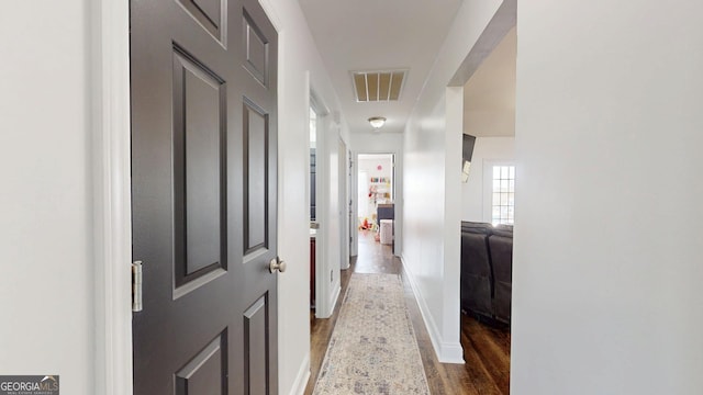 hallway featuring wood finished floors and visible vents