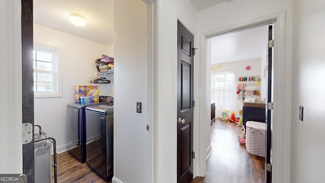 clothes washing area with dark wood finished floors, laundry area, independent washer and dryer, and baseboards