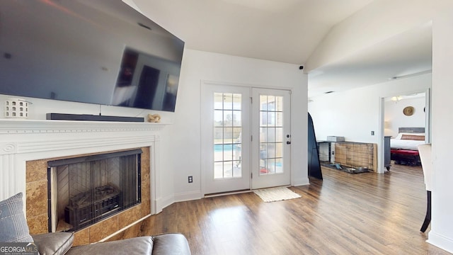 interior space featuring baseboards, lofted ceiling, wood finished floors, and a fireplace