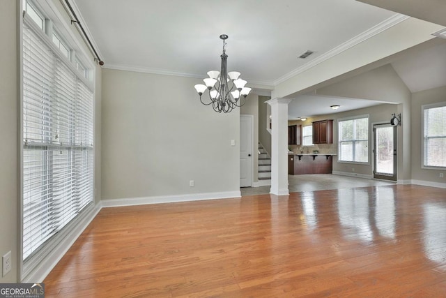 unfurnished living room featuring light wood-style floors, a chandelier, and crown molding