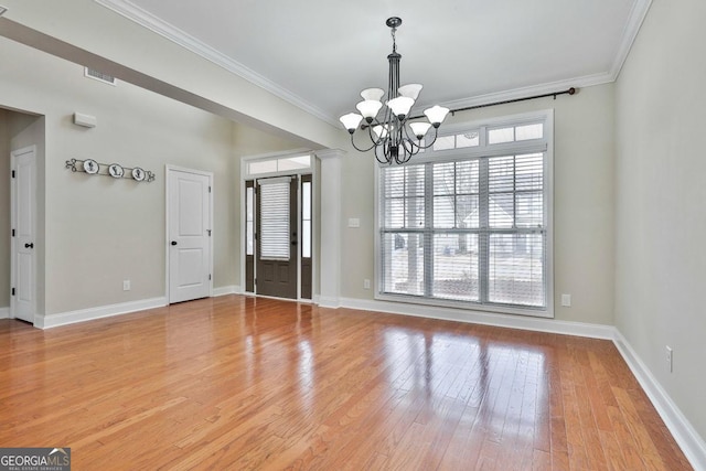 interior space featuring a notable chandelier, light wood-style flooring, crown molding, and baseboards