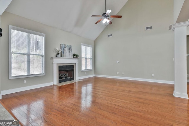 unfurnished living room with light wood finished floors, visible vents, ornate columns, and ceiling fan