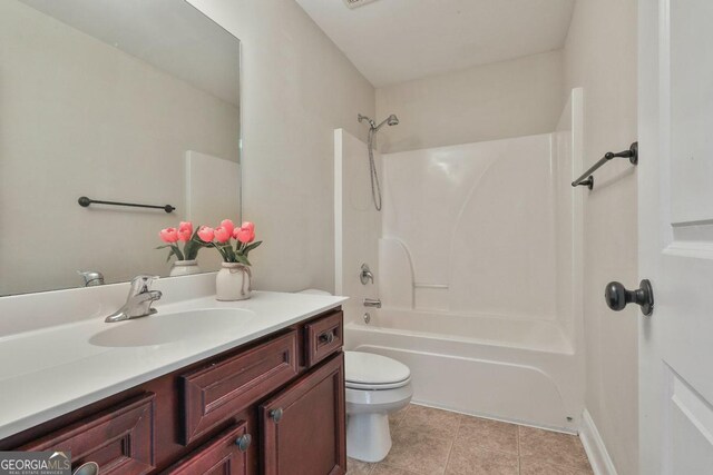 bathroom with tile patterned floors, toilet, vanity, and shower / tub combination