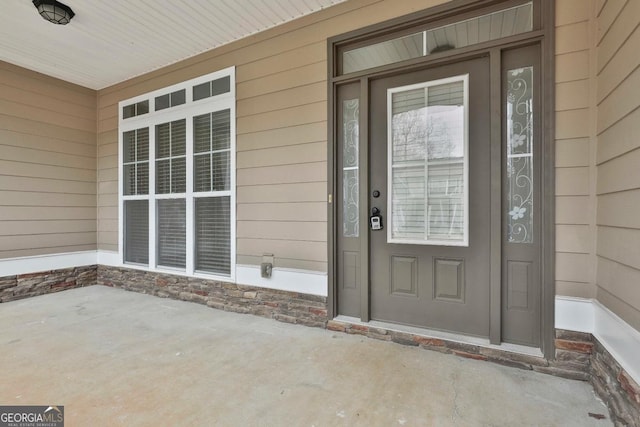 property entrance with stone siding and covered porch