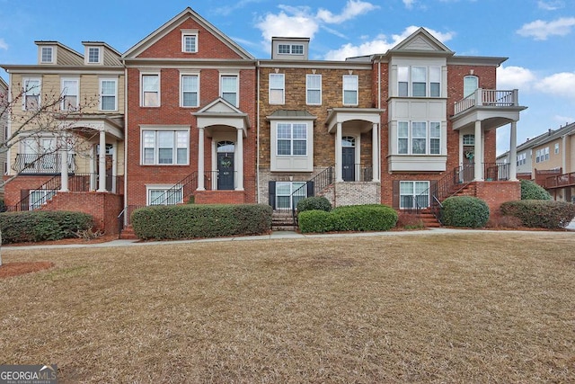 view of property featuring brick siding and a front yard