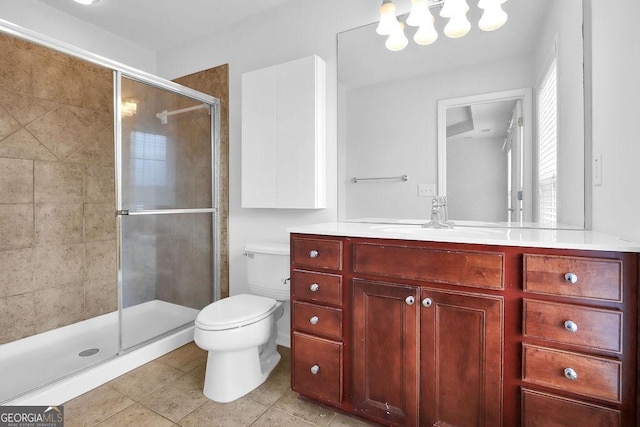 bathroom with tile patterned floors, toilet, a stall shower, a chandelier, and vanity