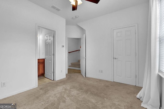 unfurnished bedroom featuring visible vents, baseboards, light colored carpet, and connected bathroom