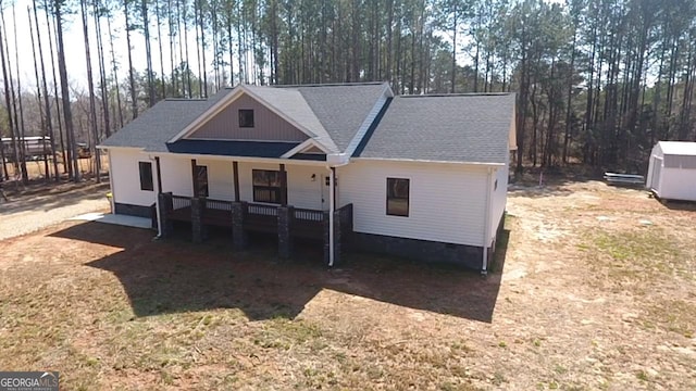 view of front of home with crawl space, covered porch, and a shingled roof