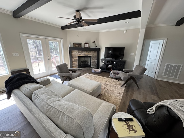 living room with dark wood finished floors, beam ceiling, visible vents, and a wealth of natural light