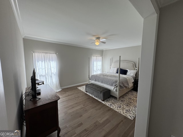 bedroom with a ceiling fan, crown molding, wood finished floors, and baseboards