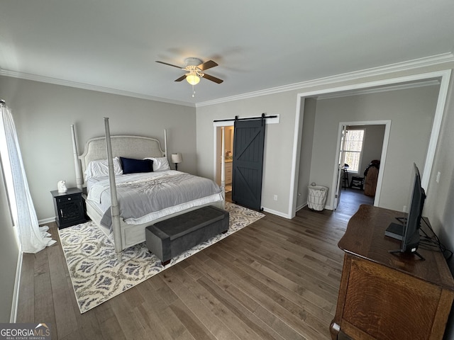 bedroom featuring baseboards, dark wood finished floors, ceiling fan, crown molding, and a barn door