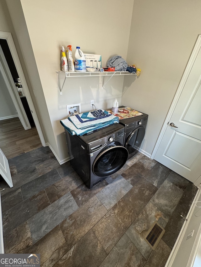 laundry room with washer and dryer, laundry area, baseboards, and stone finish flooring