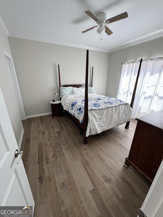 bedroom featuring crown molding, wood finished floors, and ceiling fan