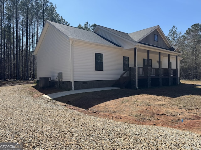 view of side of property featuring a shingled roof, central air condition unit, covered porch, and crawl space