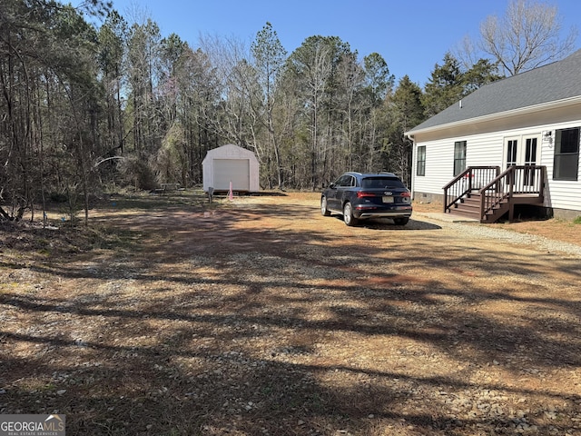 view of yard featuring a garage and an outbuilding