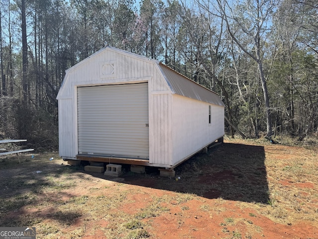 view of outdoor structure featuring an outbuilding and a wooded view