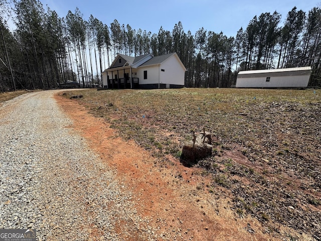 view of property exterior featuring crawl space and gravel driveway