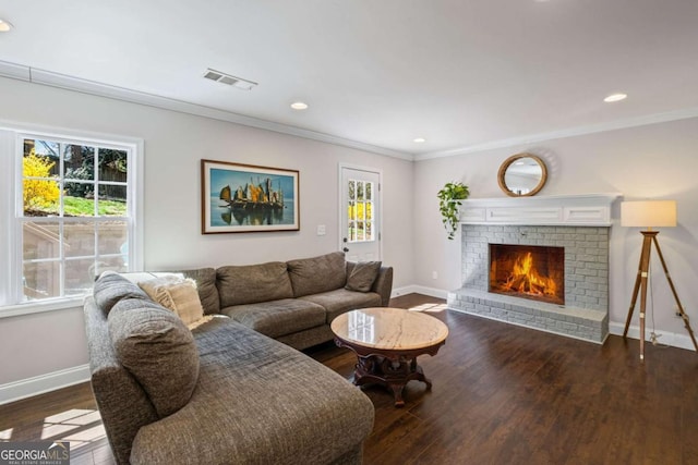 living area featuring crown molding, wood finished floors, visible vents, and baseboards