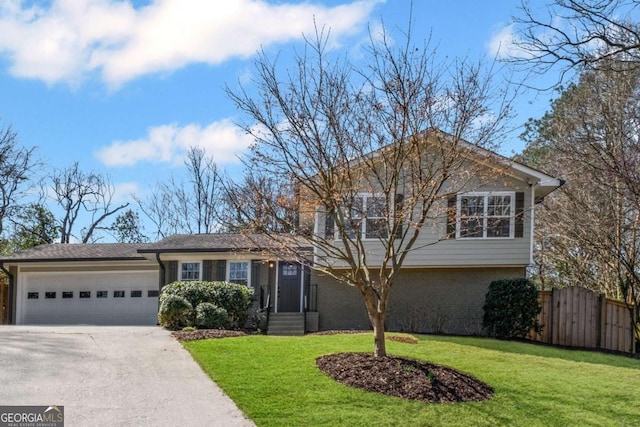 tri-level home with brick siding, fence, concrete driveway, a front yard, and a garage