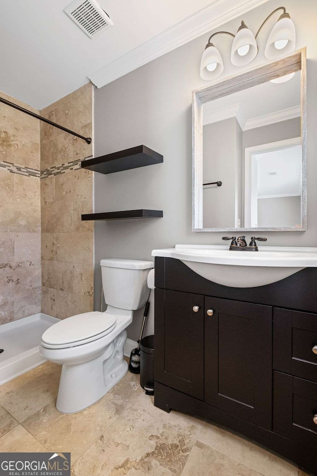 bathroom with visible vents, toilet, ornamental molding, a tile shower, and vanity