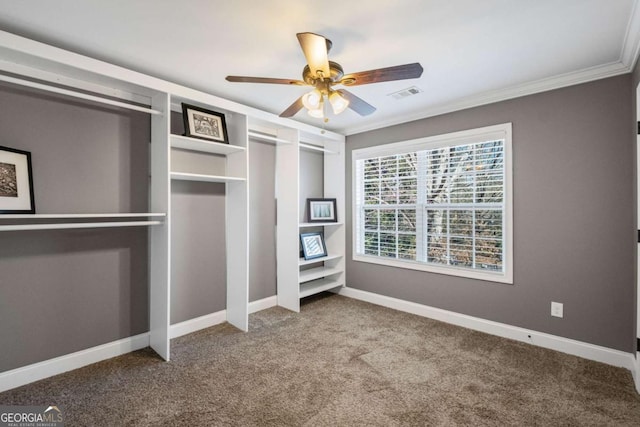 unfurnished bedroom featuring visible vents, baseboards, ornamental molding, carpet floors, and a ceiling fan