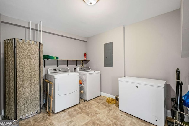 clothes washing area with washing machine and clothes dryer, laundry area, baseboards, and electric panel