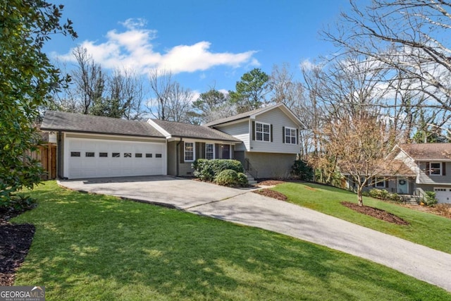 tri-level home featuring driveway, a front yard, a garage, and fence