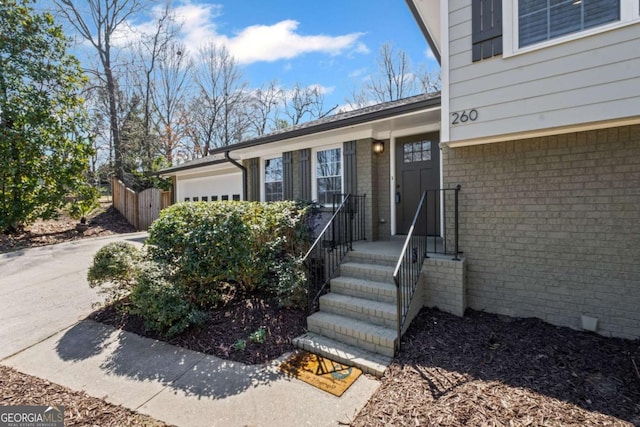 entrance to property featuring brick siding and a garage