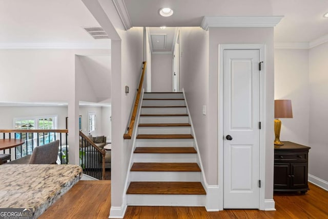 stairs with wood finished floors, baseboards, visible vents, recessed lighting, and ornamental molding