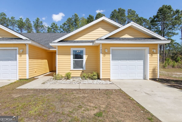 single story home featuring an attached garage, driveway, and a shingled roof