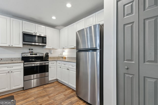 kitchen featuring appliances with stainless steel finishes, white cabinetry, and light wood-type flooring