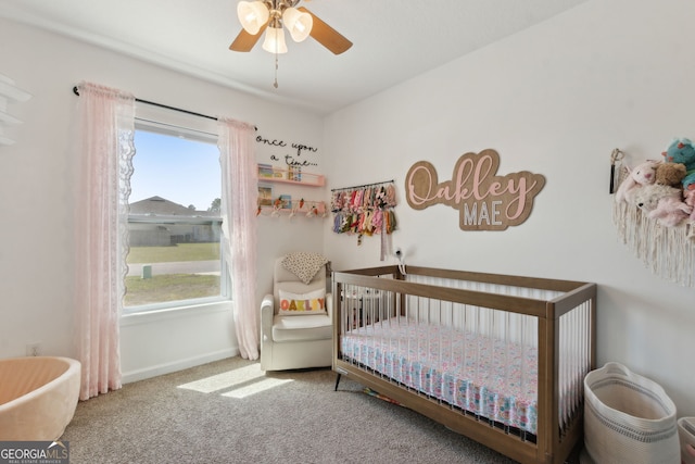 bedroom with baseboards, a ceiling fan, a nursery area, and carpet floors