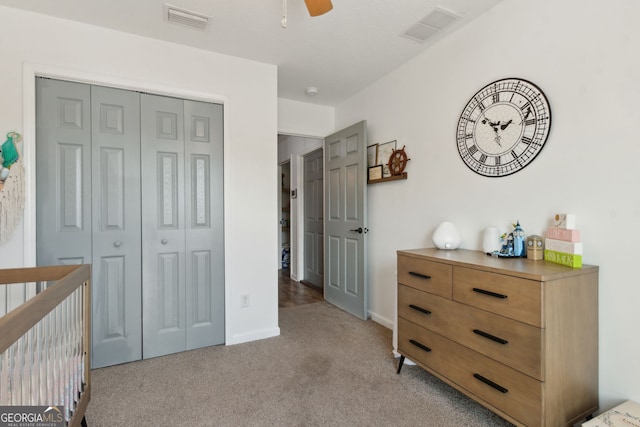 bedroom featuring a closet, visible vents, light colored carpet, and baseboards