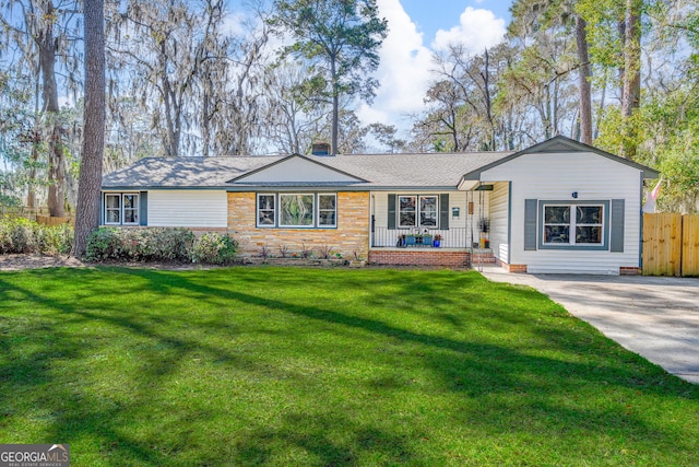 ranch-style home with covered porch, a front lawn, and fence