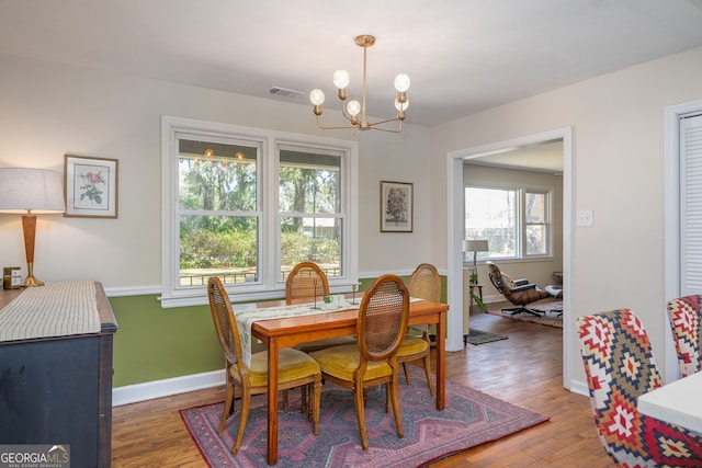 dining area featuring an inviting chandelier, light wood-style flooring, baseboards, and visible vents