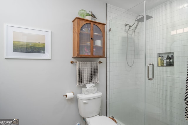 bathroom featuring toilet and a stall shower