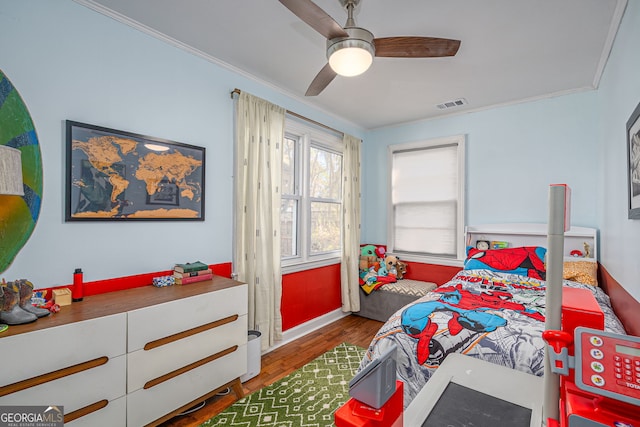 bedroom with visible vents, crown molding, a ceiling fan, and wood finished floors