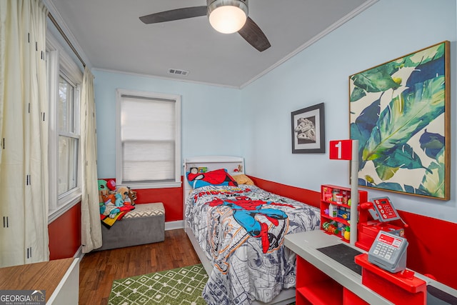 bedroom featuring ceiling fan, visible vents, wood finished floors, and crown molding