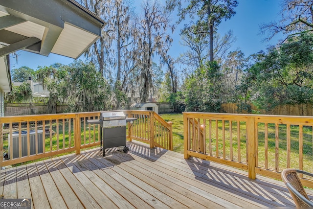 wooden deck with a yard, area for grilling, and a fenced backyard