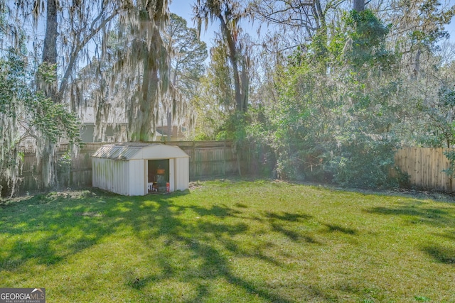 view of yard with an outbuilding, a fenced backyard, and a shed