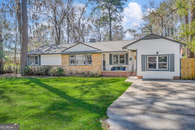 single story home featuring a front yard, fence, covered porch, a chimney, and concrete driveway