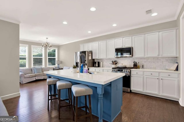 kitchen featuring white cabinetry, a notable chandelier, visible vents, and stainless steel appliances