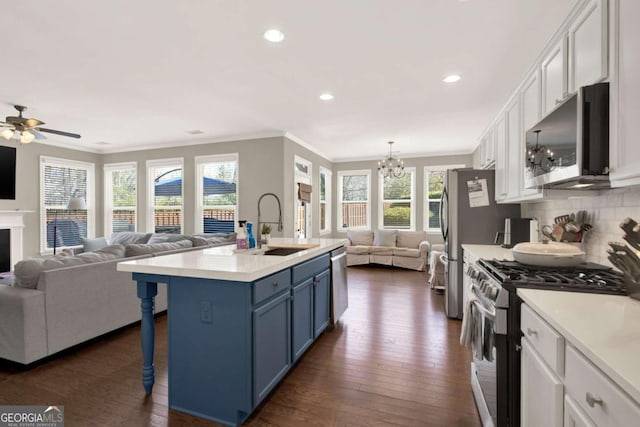 kitchen with open floor plan, white cabinets, appliances with stainless steel finishes, and blue cabinets