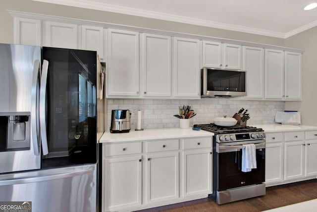 kitchen featuring ornamental molding, light countertops, appliances with stainless steel finishes, white cabinetry, and tasteful backsplash