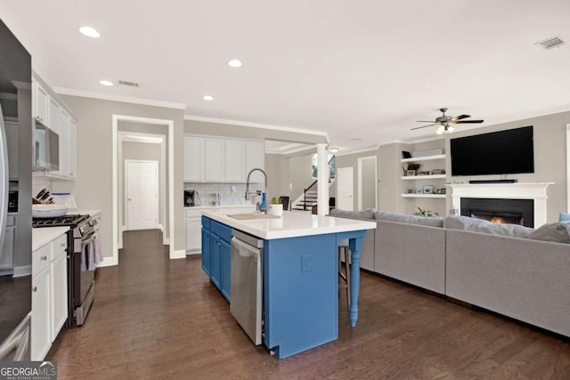 kitchen featuring visible vents, a sink, blue cabinetry, stainless steel appliances, and ceiling fan